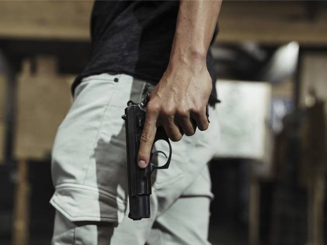 Imagen de referencia de un hombre portando una pistola. Foto: Getty Images / Westend61