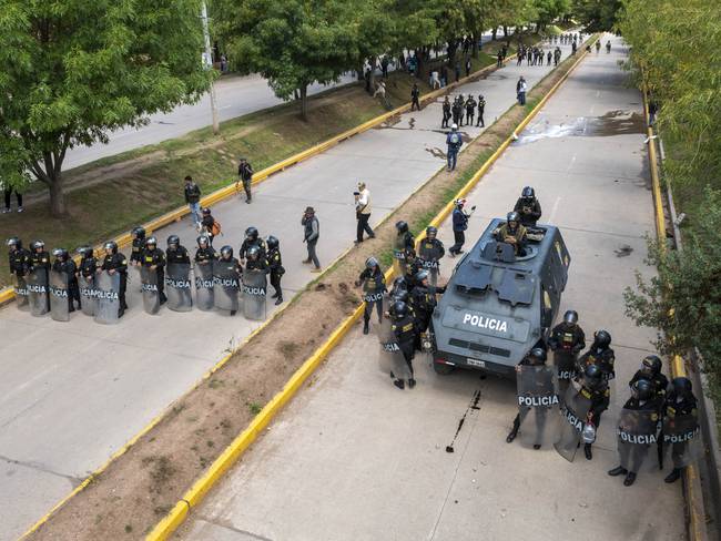 Oficiales de policía hacen guardia formando una barricada en la Avenida 28 de Julio para evitar que los manifestantes marchen hacia el Aeropuerto Internacional Alejandro Velasco Astete durante una protesta el 11 de enero de 2023 en Cusco, Perú. Foto de Michael Bednar/Getty) Imágenes.