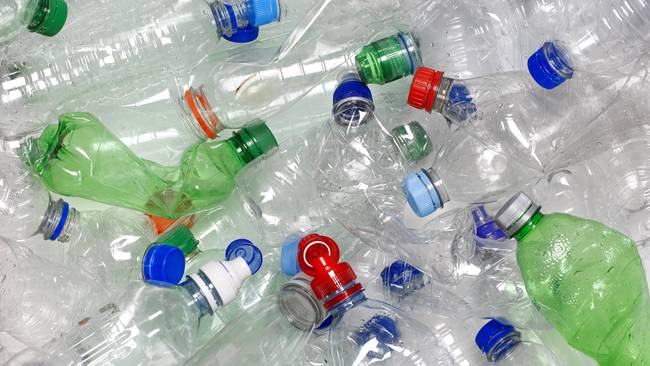 Discarded used water bottles in recycling bin.  The lids can be recycled as well if reattached to the water bottle. Photo: Getty Images.