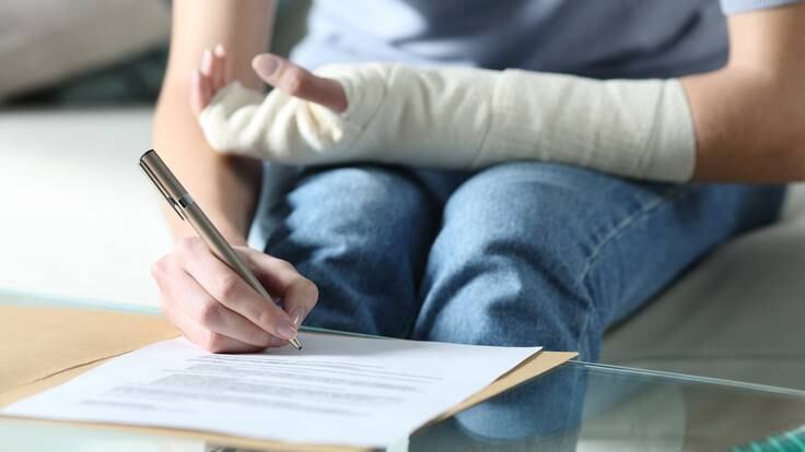 Persona incapacitada laboralmente y firmando un documento. (Foto vía Getty Images)