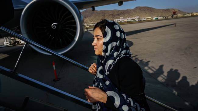 Mujer que aborda un vuelo en el aeropuerto de Kabul, Afganistán, (MARCUS YAM / LOS ANGELES TIMES)