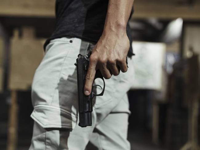 Imagen de referencia de una persona armada con una pistola. Foto: Getty Images / Westend61