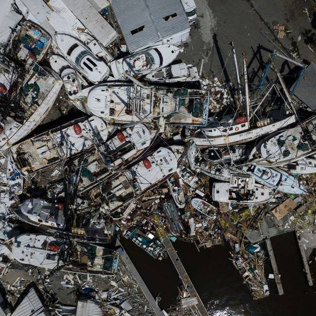 An aerial picture taken on September 29, 2022 shows piled up boats in the aftermath of Hurricane Ian in Fort Myers, Florida. - Hurricane Ian left much of coastal southwest Florida in darkness early on Thursday, bringing &quot;catastrophic&quot; flooding that left officials readying a huge emergency response to a storm of rare intensity. The National Hurricane Center said the eye of the &quot;extremely dangerous&quot; hurricane made landfall just after 3:00 pm (1900 GMT) on the barrier island of Cayo Costa, west of the city of Fort Myers. (Photo by Ricardo ARDUENGO / AFP) (Photo by RICARDO ARDUENGO/AFP via Getty Images)