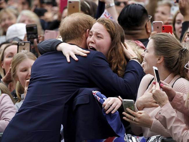 El príncipe Harry decidió abrazar a una joven que lo estaba esperando desde las 4:00 a.m.. Foto: Associated Press - AP