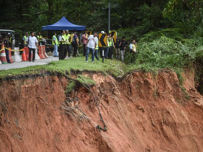 Personas inspeccionan los daños después de un deslizamiento de tierra en Batang Kali, Selangor, el 16 de diciembre de 2022.