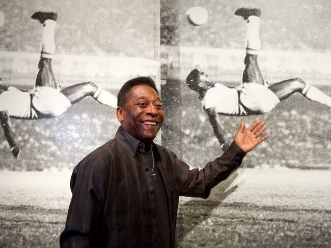 Pelé frente a una fotografía de sus goles más icónicos. Foto: JUSTIN TALLIS/AFP via Getty Images