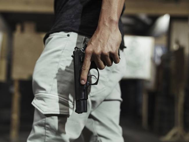 Imagen de referencia de una persona armada con pistola. Foto: Getty Images / Westend61