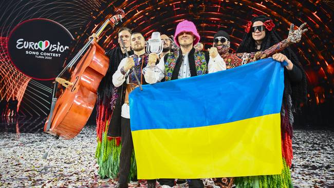 TOPSHOT - Members of the band &quot;Kalush Orchestra&quot; pose onstage with the winner&#039;s trophy and Ukraine&#039;s flags after winning on behalf of Ukraine the Eurovision Song contest 2022 on May 14, 2022 at the Pala Alpitour venue in Turin. (Photo by Marco BERTORELLO / AFP) (Photo by MARCO BERTORELLO/AFP via Getty Images)