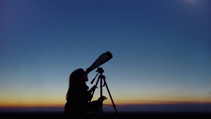 Mujer observando el eclipse solar total a través de un telescopio (Foto vía GettyImages)
