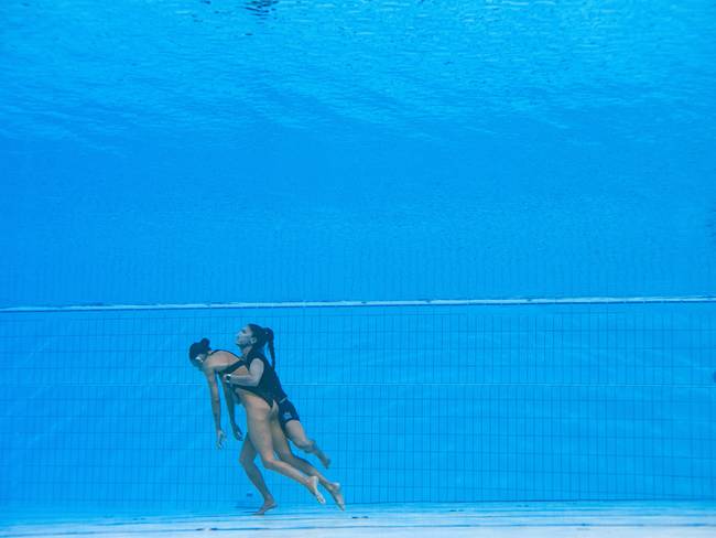A member of Team USA (R) recovers USA&#039;s Anita Alvarez (L), from the bottom of the pool during an incident in the women&#039;s solo free artistic swimming finals, during the Budapest 2022 World Aquatics Championships at the Alfred Hajos Swimming Complex in Budapest on June 22, 2022. (Photo by Oli SCARFF / AFP)