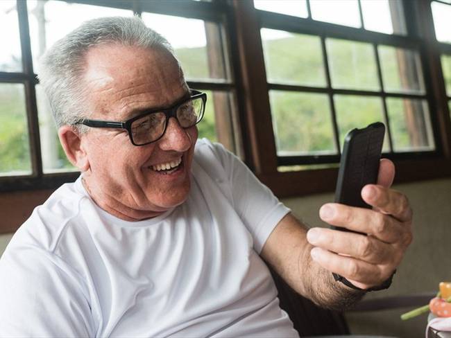 Imagen de referencia de un hombre usando un celular. Foto: Getty Images / Igor Alecsander