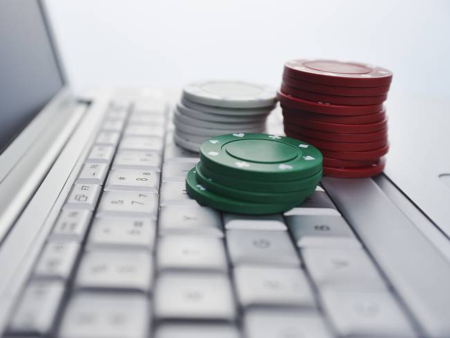 Gambling chips on computer keyboard - Getty Images