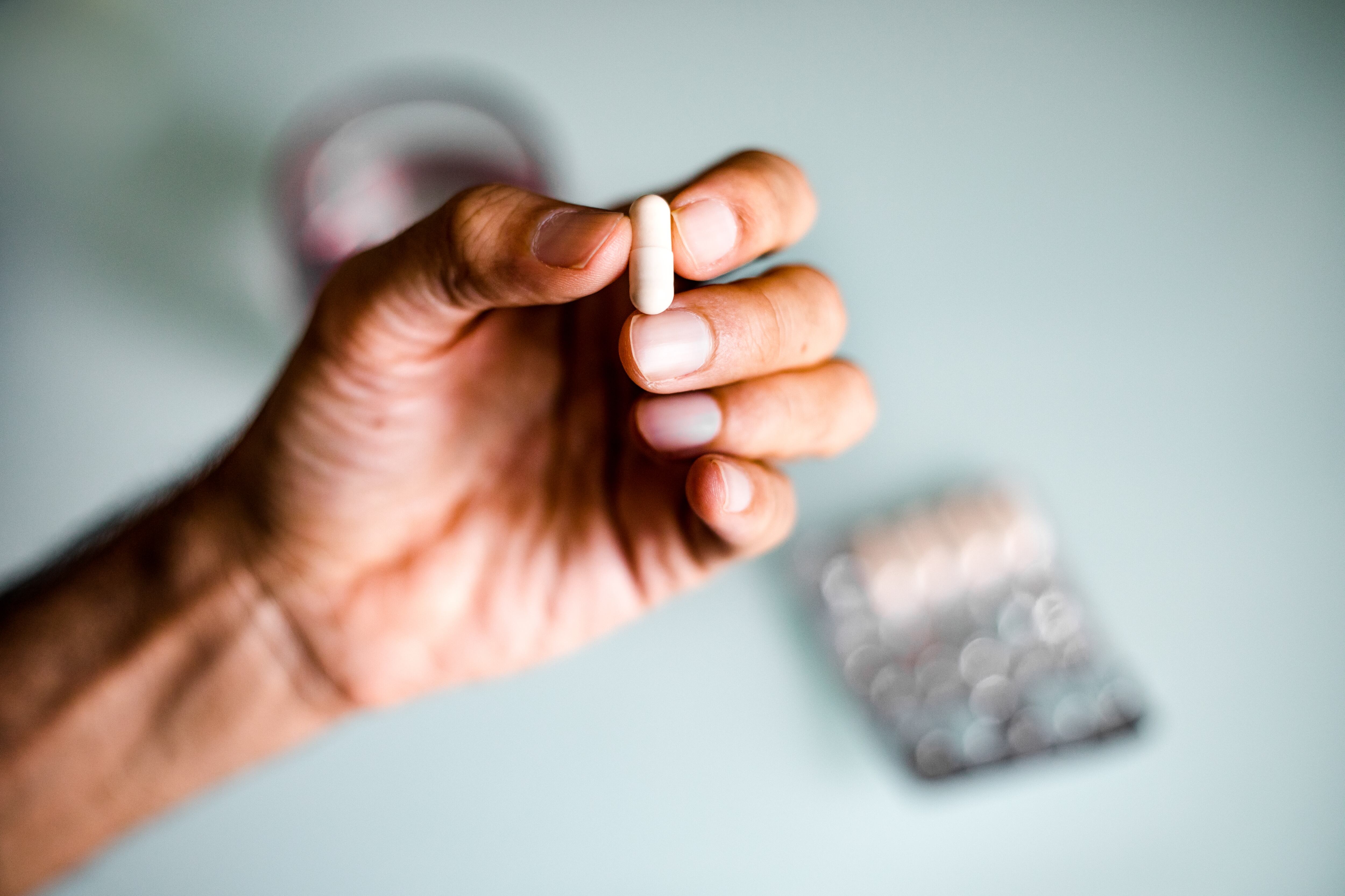 Close up of unrecognizable man taking meds/ supplements / medicine