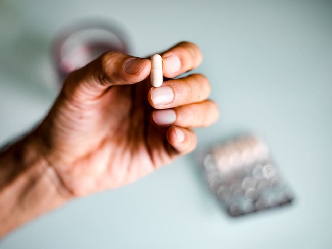 Close up of unrecognizable man taking meds/ supplements / medicine