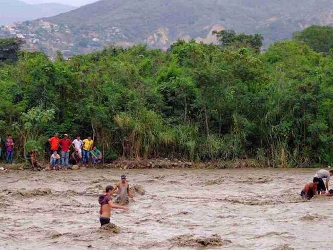 En improvisadas canoas extranjeros intentan cruzar a Colombia por el río Táchira. Foto: Reuters