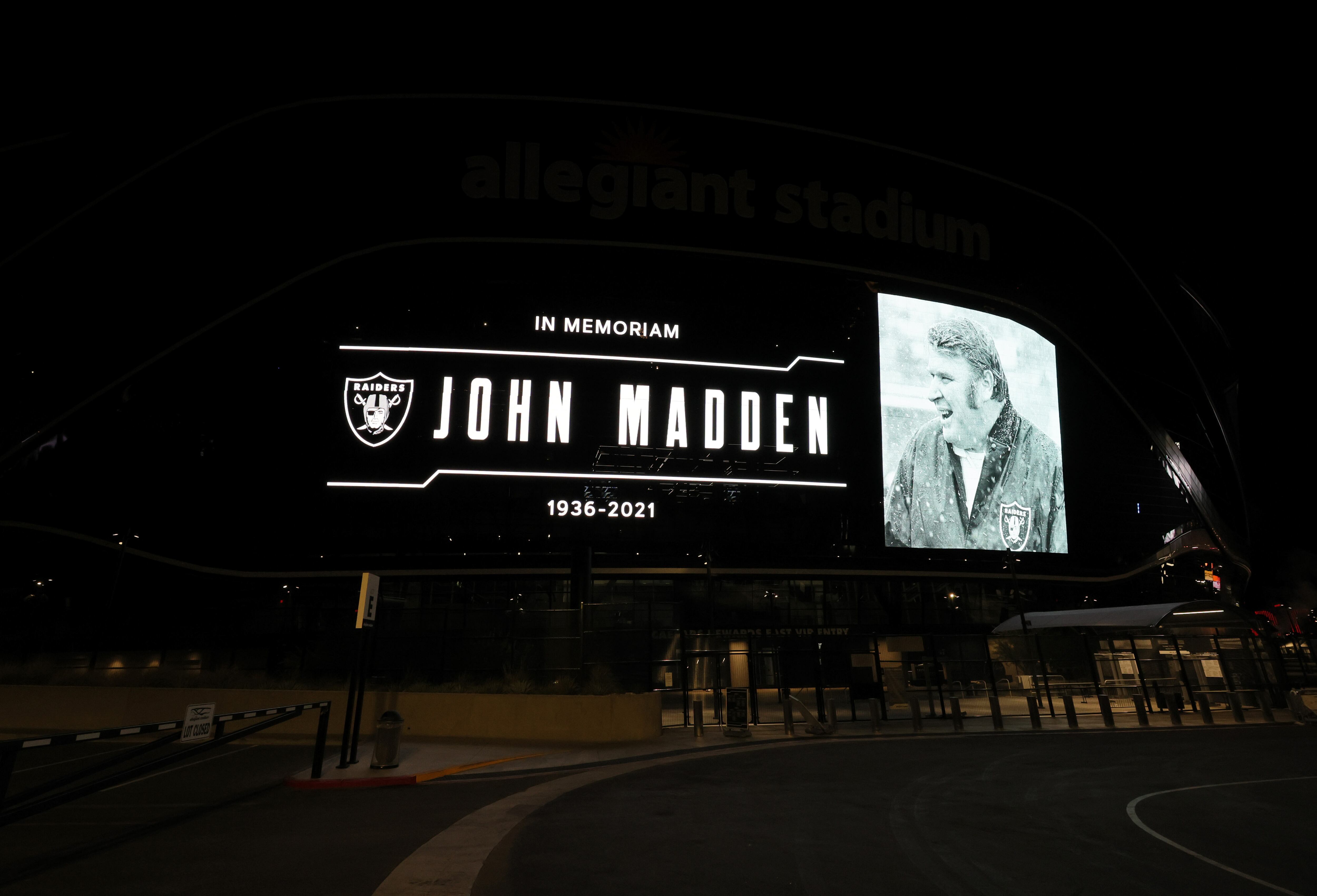 LAS VEGAS, NEVADA - DECEMBER 28:  A tribute to former Raiders head coach, Pro Football Hall of Fame member and broadcaster John Madden is displayed on the side of Allegiant Stadium, home of the Las Vegas Raiders, after news of his death at the age of 85 on December 28, 2021 in Las Vegas, Nevada. Madden coached the Oakland Raiders for 10 seasons and won the team's first championship with a win over the Minnesota Vikings in Super Bowl XI in 1977. Owner and managing general partner Mark Davis of the Las Vegas Raiders lit the Al Davis Memorial Torch inside the stadium before the organization turned off all the exterior lights, except for the memorial message, in honor of Madden.  (Photo by Ethan Miller/Getty Images)