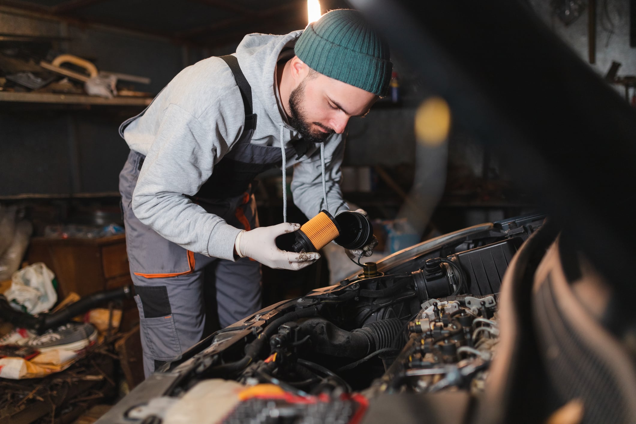 Mecánico cambiando el filtro del aceite en el carro (Getty Images)