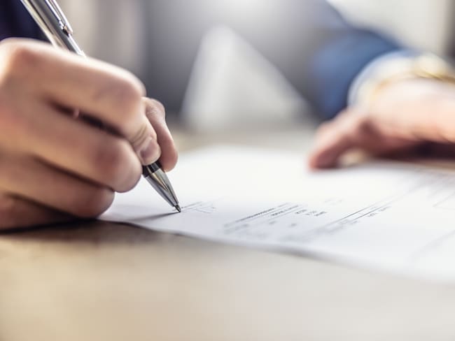 Imagen de referencia de una persona firmando un contrato. Foto: Getty Images.