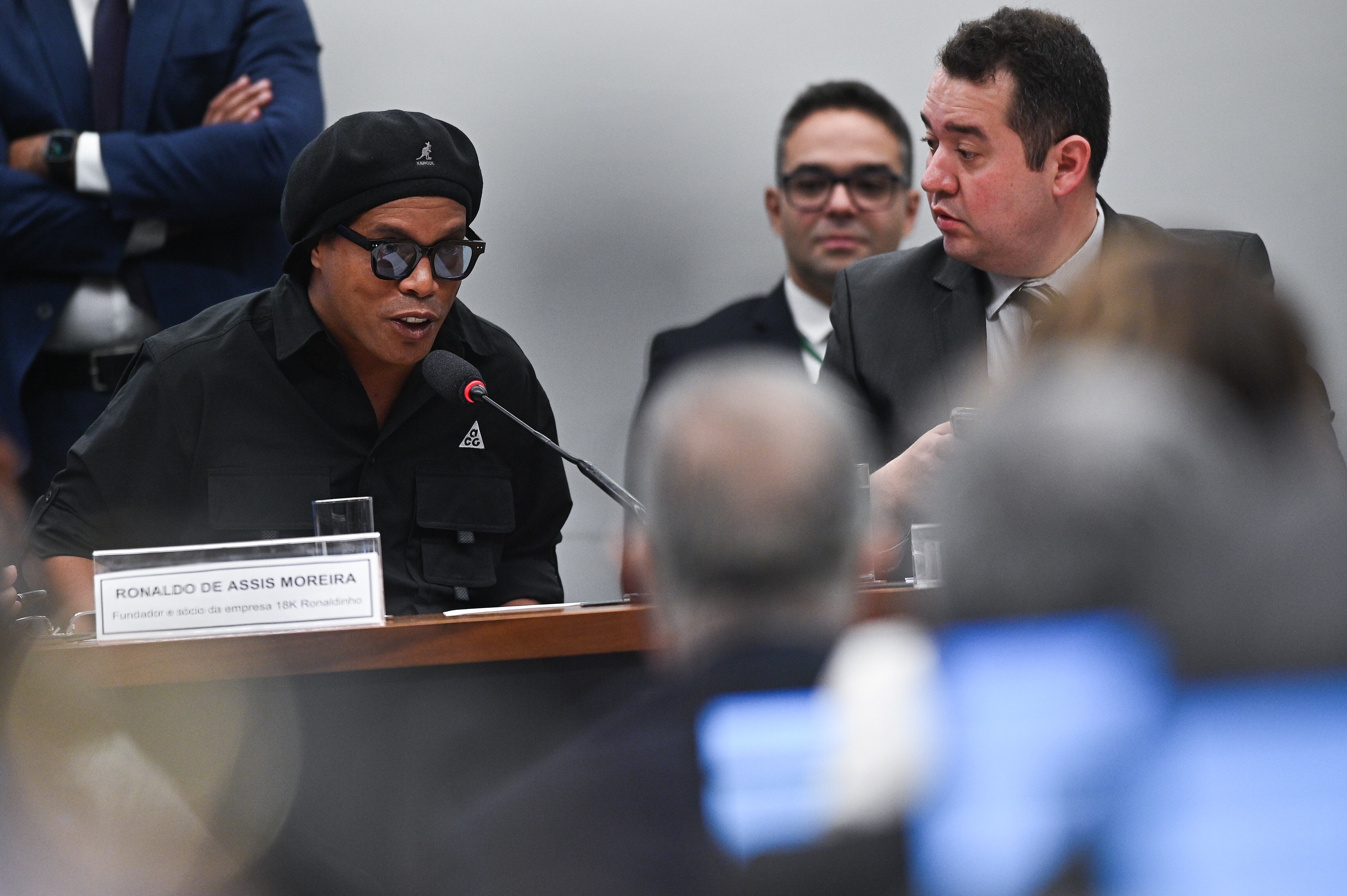 -FOTODELDÍA- BRA50. BRASILIA (BRASIL), 31/08/2023. - El exfutbolista brasileño Ronaldinho Gaúcho (i) declara hoy ante una comisión de la Cámara de Diputados de Brasil que investiga fraudes con pirámides financieras, en la sede del Congreso en Brasilia (Brasil). Ronaldinho alegó este jueves ante una comisión del Congreso que su nombre fue usado indebidamente por dos socios acusados de una estafa y con los que tan sólo tenía un contrato para promover una marca de relojes. EFE/André Borges