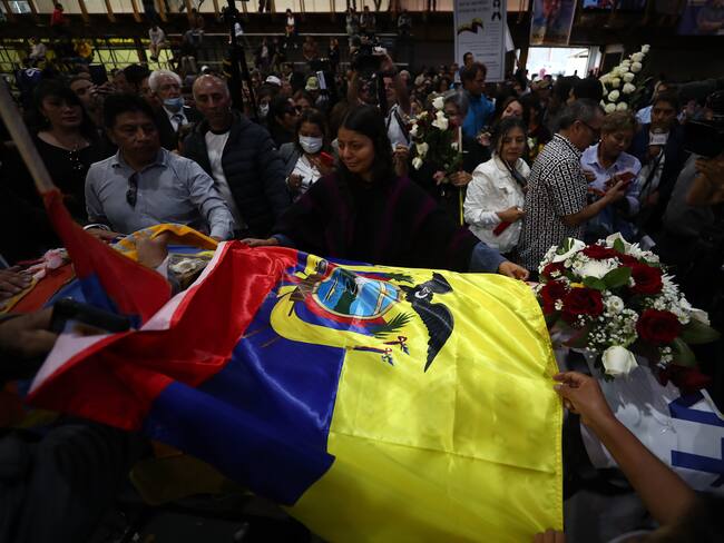 AME9921. QUITO (ECUADOR), 11/08/2023.- Simpatizantes colocan una bandera nacional sobre el féretro del candidato Fernando Villavicencio, durante un velatorio público en el Centro de Exposiciones hoy, en Quito (Ecuador). El féretro de Villavicencio, el candidato a la Presidencia de Ecuador asesinado el miércoles, salió del cementerio al que había sido trasladado para tener un breve velatorio público antes de regresar al camposanto y proceder con su inhumación. Los simpatizantes tuvieron la oportunidad de dar el último adiós a Villavicencio después de que llegaran hasta los exteriores del tanatorio y luego del cementerio para insistir en que se celebrara un velatorio público. EFE/ José Jácome