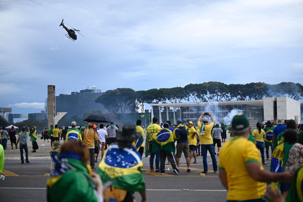 BRASILIA, BRAZIL - JANUARY 08: Bolsonaro supporters storm the National Congress in Brasilia, Brazil, 08 January 2023. Hundreds of supporters of former President Jair Bolsonaro raided the National Congress in Brazil on Sunday. Groups shouting slogans demanding intervention from the army broke through the police barrier and entered the Congress building, according to local media. Police intervened with tear gas to disperse pro-Bolsonaro protesters. Some demonstrators were seen climbing onto the roofs of the House of Representatives and Senate buildings. (Photo by Mateus Bonomi/Anadolu Agency via Getty Images)