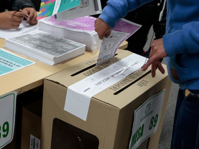 Persona introduciendo tarjetón con el voto en elecciones (Colprensa)