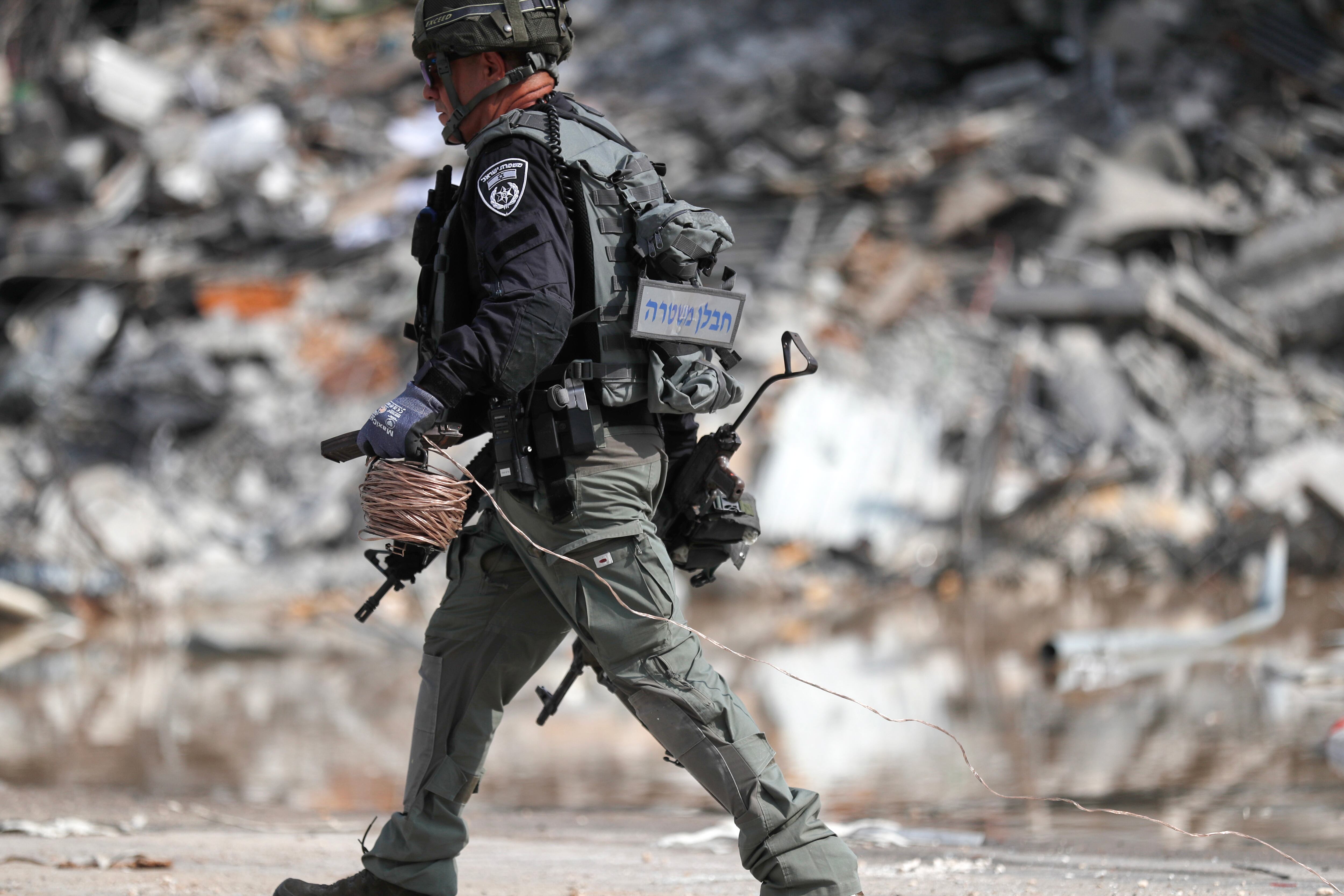 Sderot (Israel), 08/10/2023.- A member of the Israeli security forces carries a weapon used by Hamas fighters at the site of the destroyed police station that was controlled by Hamas militants in the southern city of Sderot, close to the Gaza border, Israel, 08 October 2023. Rocket barrages were launched from the Gaza Strip as of early 07 October in a surprise attack claimed by the Islamist movement Hamas. More than 300 Israelis were killed and over 1,000 left injured in the attacks, the Israeli foreign ministry said. EFE/EPA/ATEF SAFADI