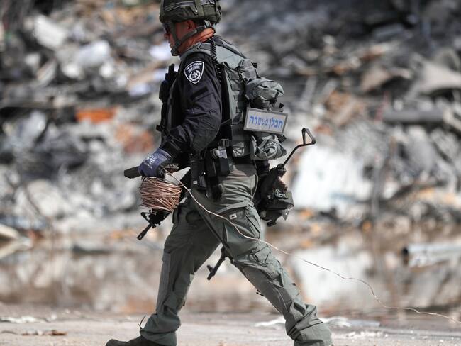 Sderot (Israel), 08/10/2023.- A member of the Israeli security forces carries a weapon used by Hamas fighters at the site of the destroyed police station that was controlled by Hamas militants in the southern city of Sderot, close to the Gaza border, Israel, 08 October 2023. Rocket barrages were launched from the Gaza Strip as of early 07 October in a surprise attack claimed by the Islamist movement Hamas. More than 300 Israelis were killed and over 1,000 left injured in the attacks, the Israeli foreign ministry said. EFE/EPA/ATEF SAFADI
