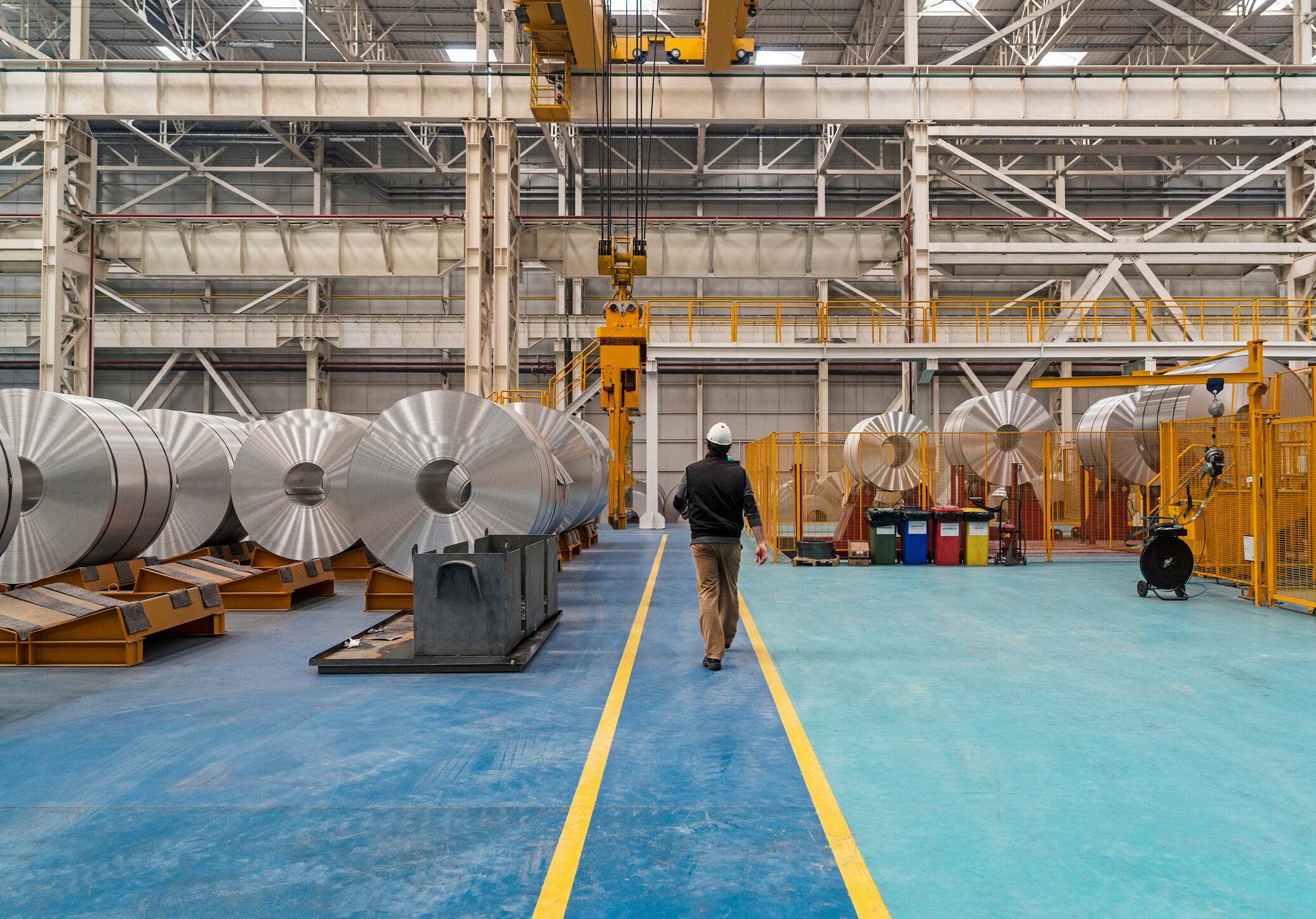 Large aluminum steel rolls in the factory. Also you can see the overhead crane and a worker walking. Image taken in daylight with a Sony A7Rii (42 megapixels) and developed from raw.. This pictures were taken in Asas Aluminium Factory in Turkey with a special permission together with property release.