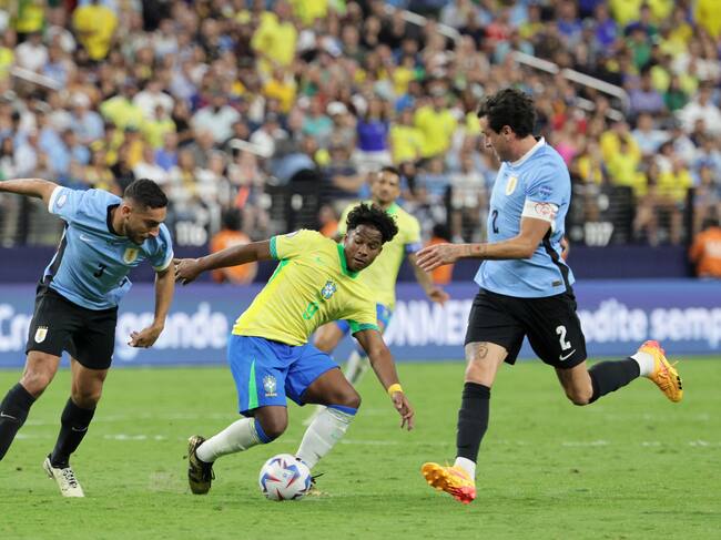 Las Vegas (United States), 07/07/2024.- Endrick Moreira of Brazil (C) in action against Sebastian Caceres of Uruguay and Jose Gimenez of Uruguay (R) during the CONMEBOL Copa America 2024 Quarter-finals match between Uruguay and Brazil, in Las Vegas, Nevada, USA, 06 July 2024. (Brasil) EFE/EPA/ALLISON DINNER