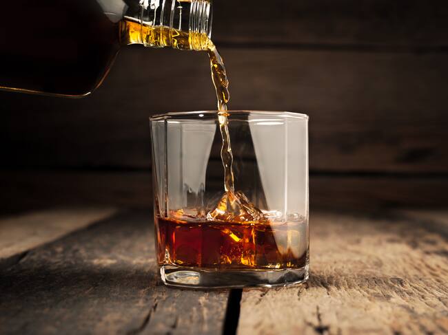 Pouring glass of whiskey, Close-up whisky on the rocks.