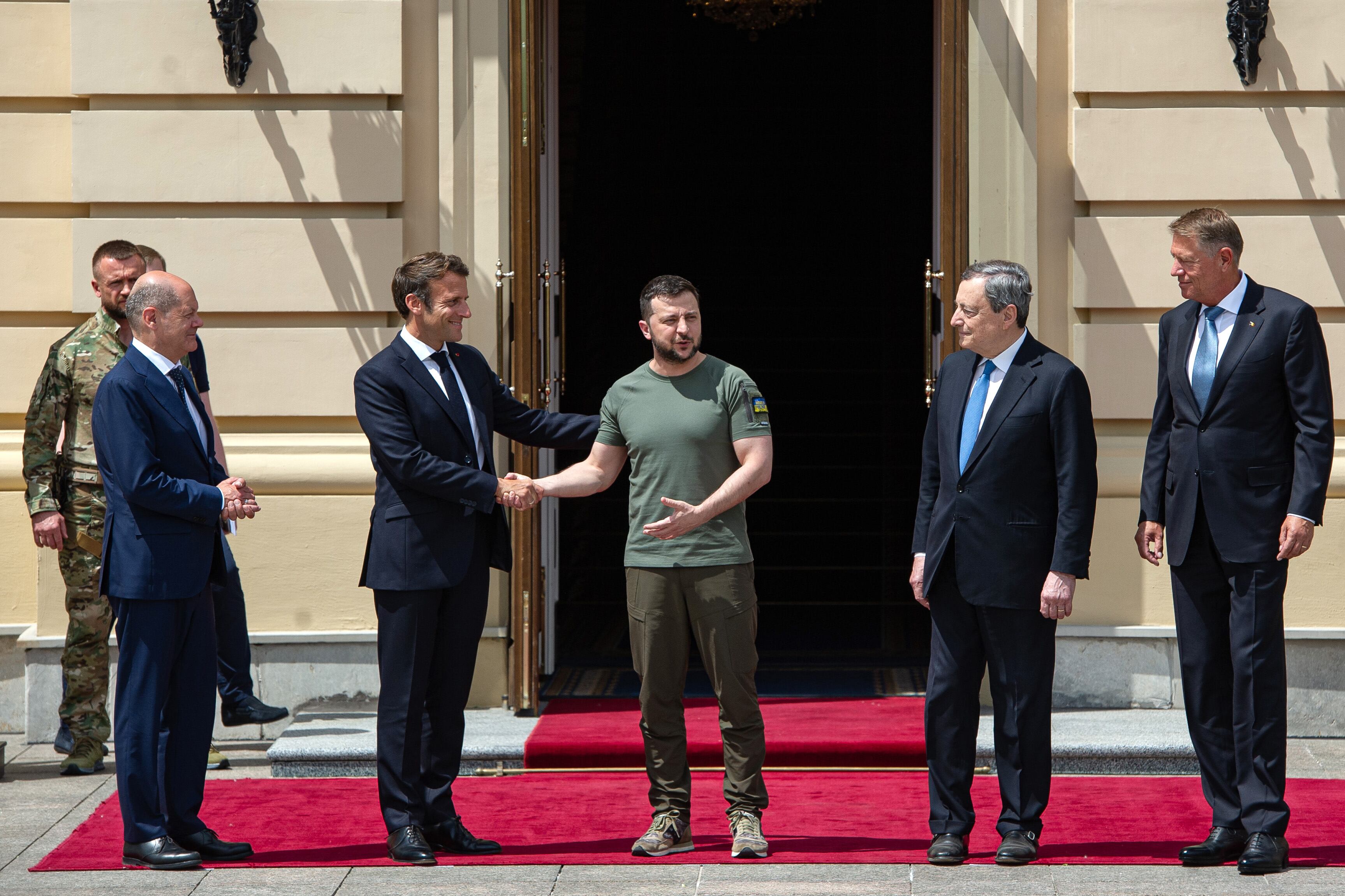 KYIV, UKRAINE - JUNE 16: Ukrainian President Volodymyr Zelensky shakes hands with France's President Emmanuel Macron as German Chancellor Olaf Scholz, Italian Prime Minister Mario Draghi and Romanian President Klaus Iohannis look on June 16, 2022 in Kyiv, Ukraine. The leaders made their first visits to Ukraine since the country was invaded by Russia on February 24th. (Photo by Alexey Furman/Getty Images)