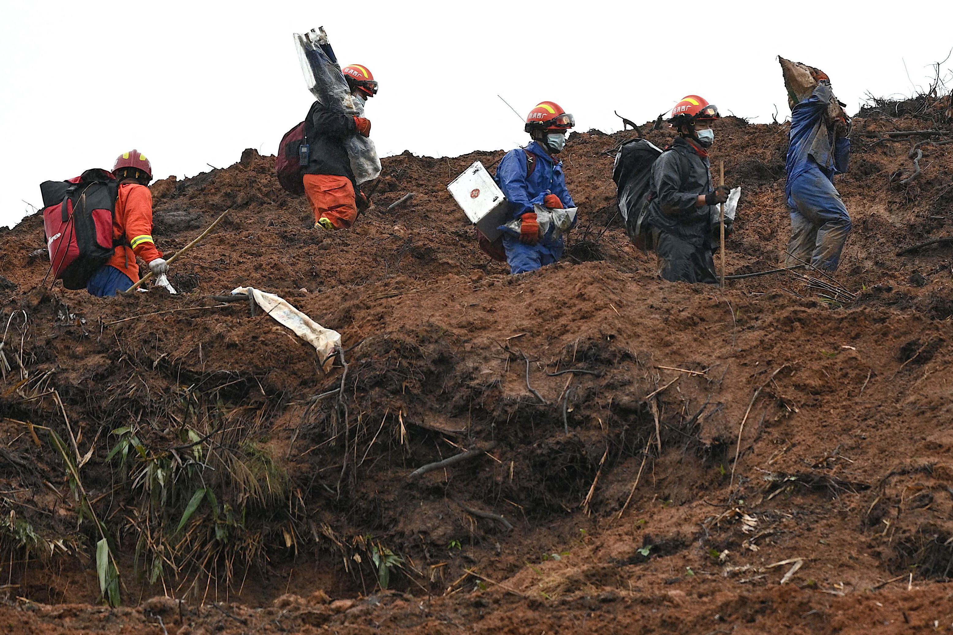 Rescue workers comb through the site of where China Eastern flight MU5375 crashed on March 21, near Wuzhou in southwestern Chinas Guangxi province on March 24, 2022. - The cause of the disaster which killed 132 people has mystified aviation authorities who have scoured rugged terrain for clues, finding no survivors from what is almost certain to be China's deadliest plane crash in nearly 30 years. (Photo by Noel Celis / AFP) (Photo by NOEL CELIS/AFP via Getty Images)