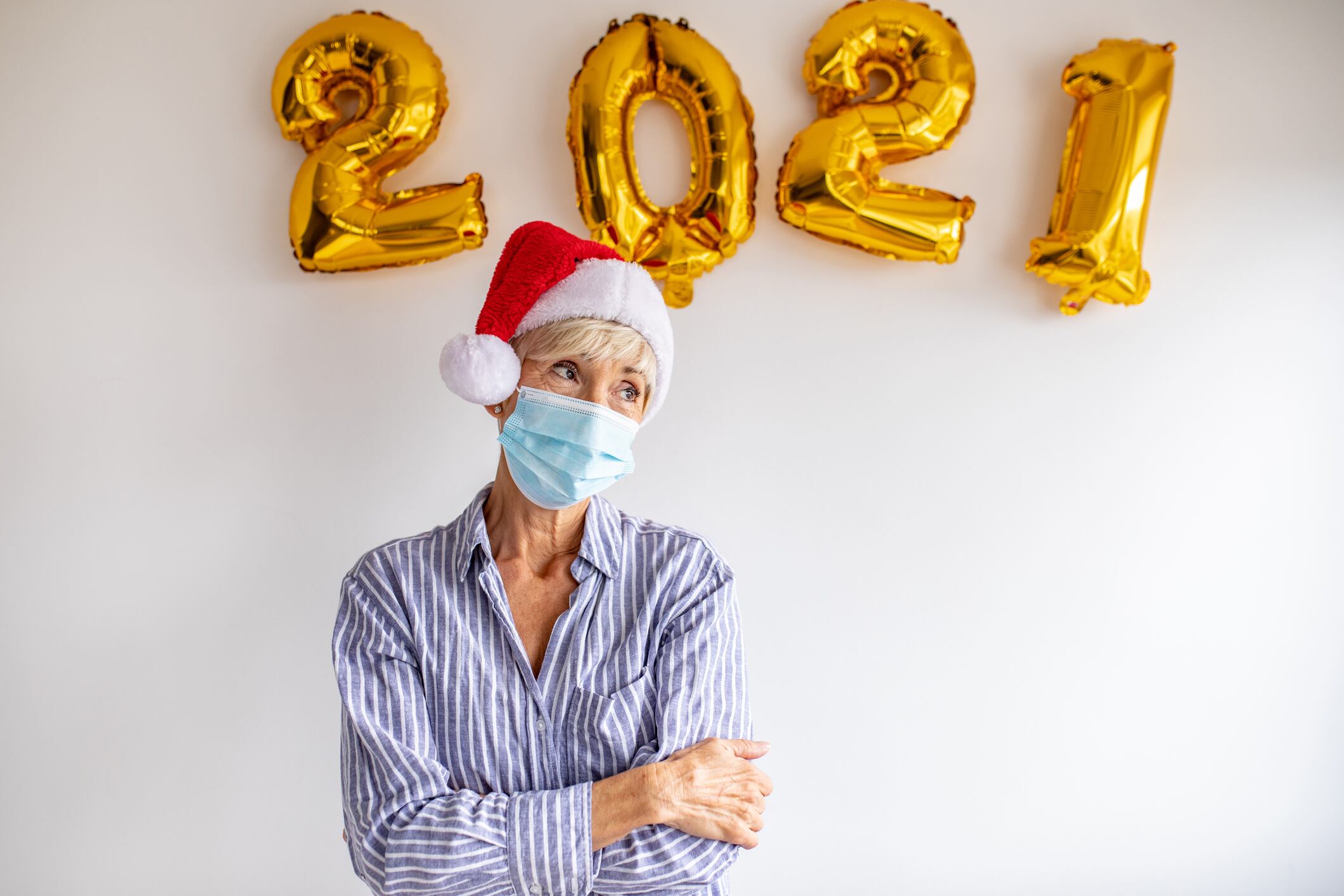 Senior woman wearing protective face mask with 2021 numbers behind her