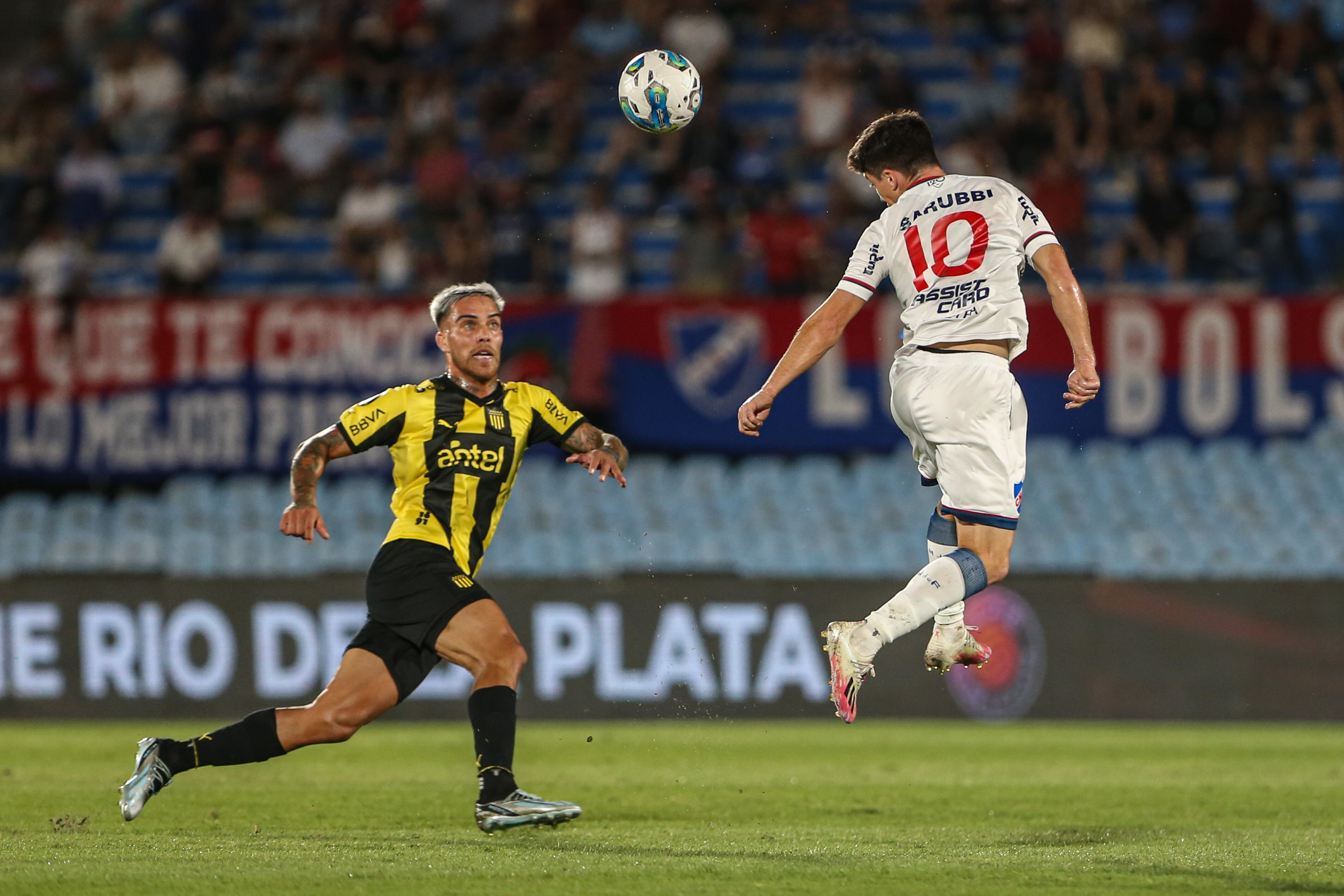 -FOTODELDÍA- AME1759. MONTEVIDEO (URUGUAY), 23/01/2024.- Pereyra (d) de Nacional salta por un balón hoy, durante un partido amistoso entre Peñarol y Nacional de la serie del Río de la Plata, en el estadio Centenario, en Montevideo (Uruguay). EFE/ Gaston Britos