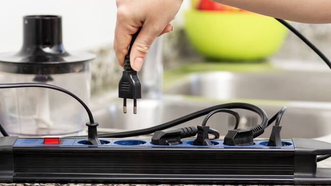 Enchufar un electrodoméstico en una multitoma (GettyImages)
