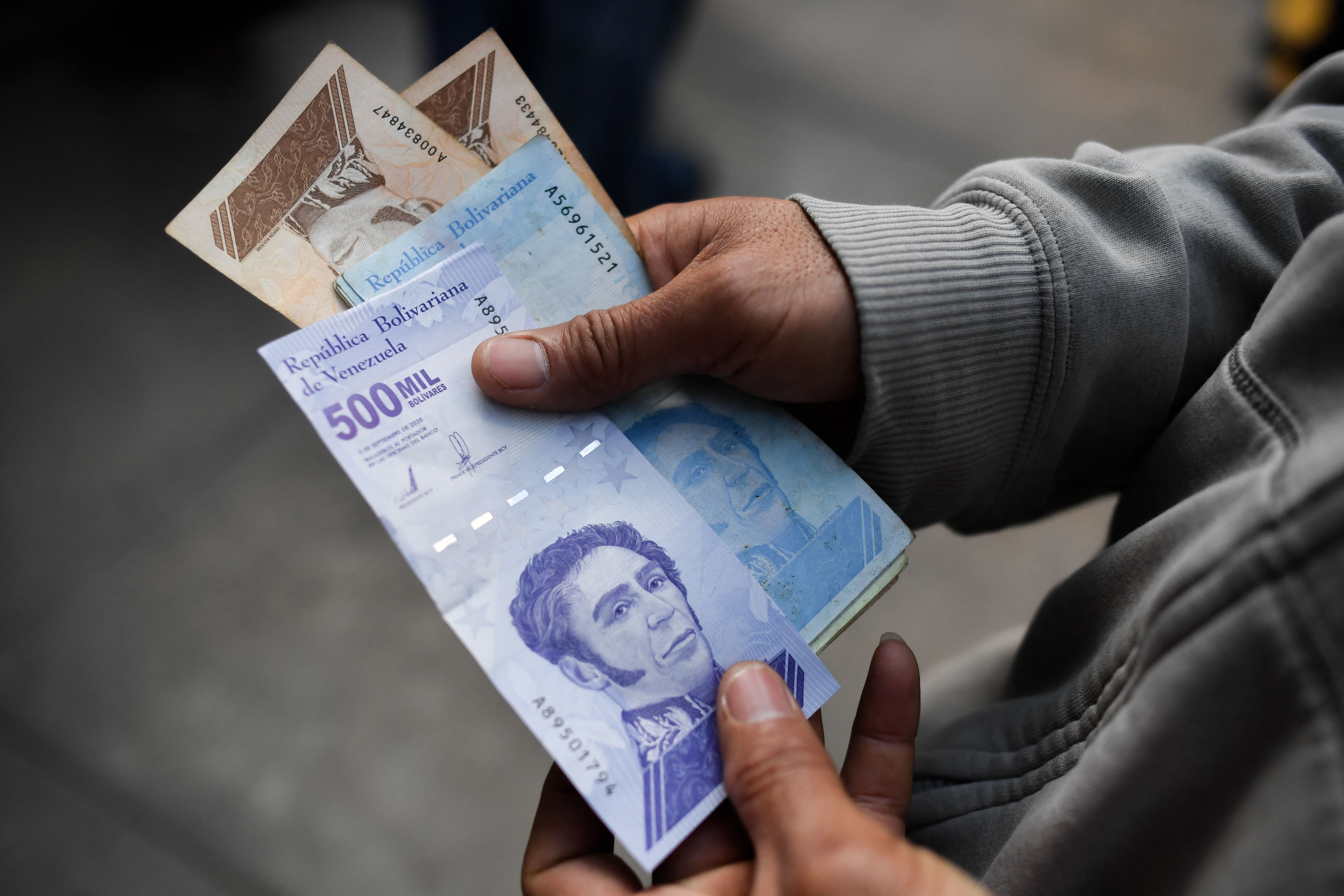 Un hombre sostiene el nuevo billete de quinientos mil bolívares tras salir de un banco en Caracas, el 15 de marzo de 2021. (Foto de FEDERICO PARRA/AFP via Getty Images)