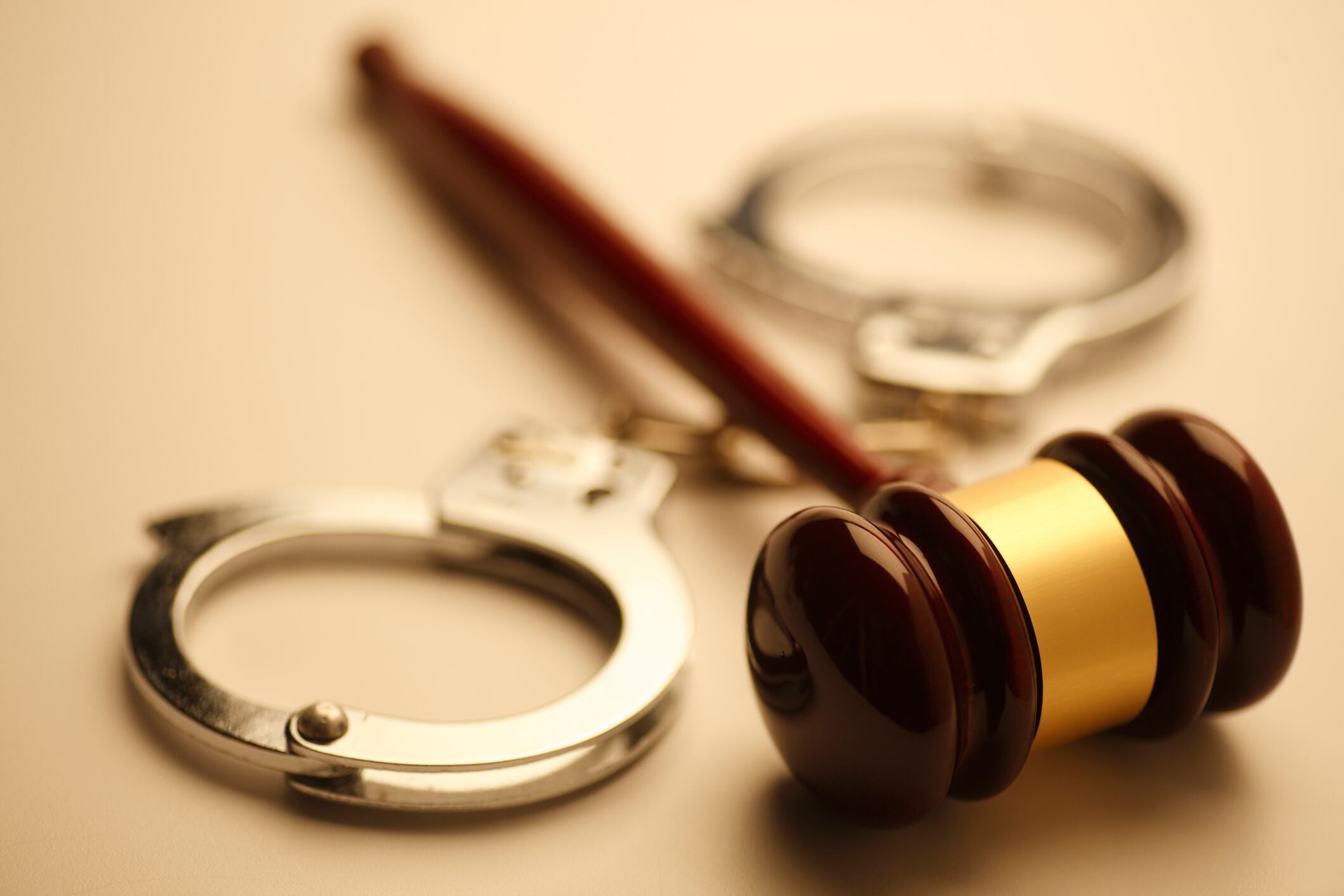 A gavel and a pair of handcuffs. Shot with shallow depth of field.