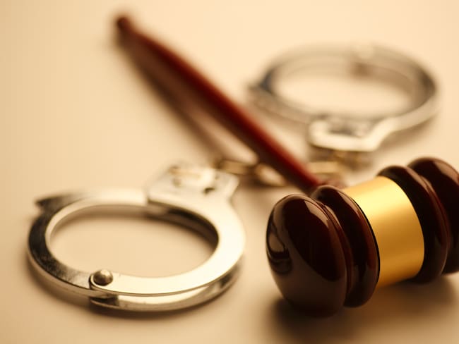 A gavel and a pair of handcuffs. Shot with shallow depth of field.