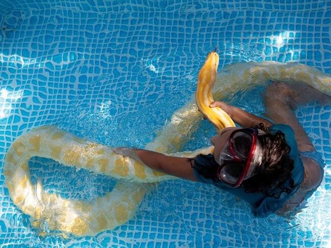 La niña con su pitón. Foto: Reuters.