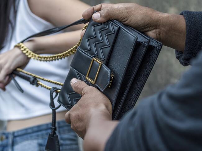 Asian women tourist pulling her bag from thieves who are stealing a handbag.