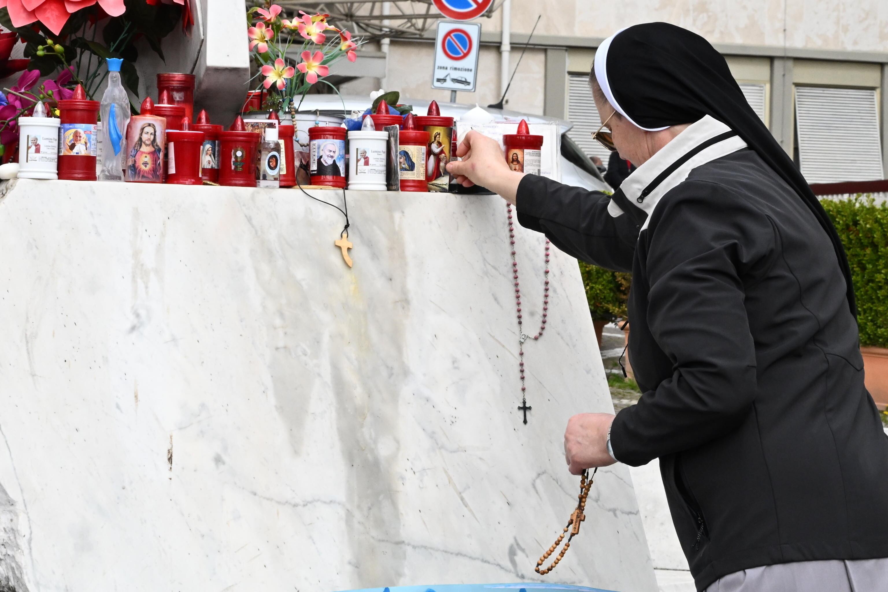 ROMA (Italia), 27/02/2025.- Una monja deja una imagen sagrada en una estatua del papa San Juan Pablo II en el exterior del Hospital Universitario Gemelli, donde está hospitalizado el papa Francisco.