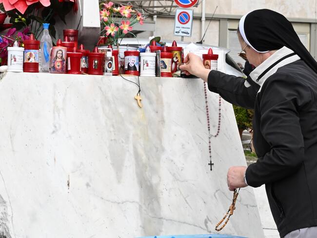 ROMA (Italia), 27/02/2025.- Una monja deja una imagen sagrada en una estatua del papa San Juan Pablo II en el exterior del Hospital Universitario Gemelli, donde está hospitalizado el papa Francisco.