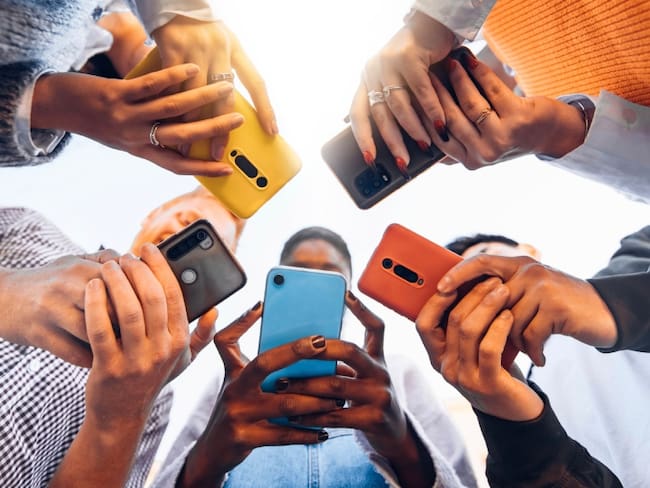 Jóvenes sosteniendo celulares en sus manos