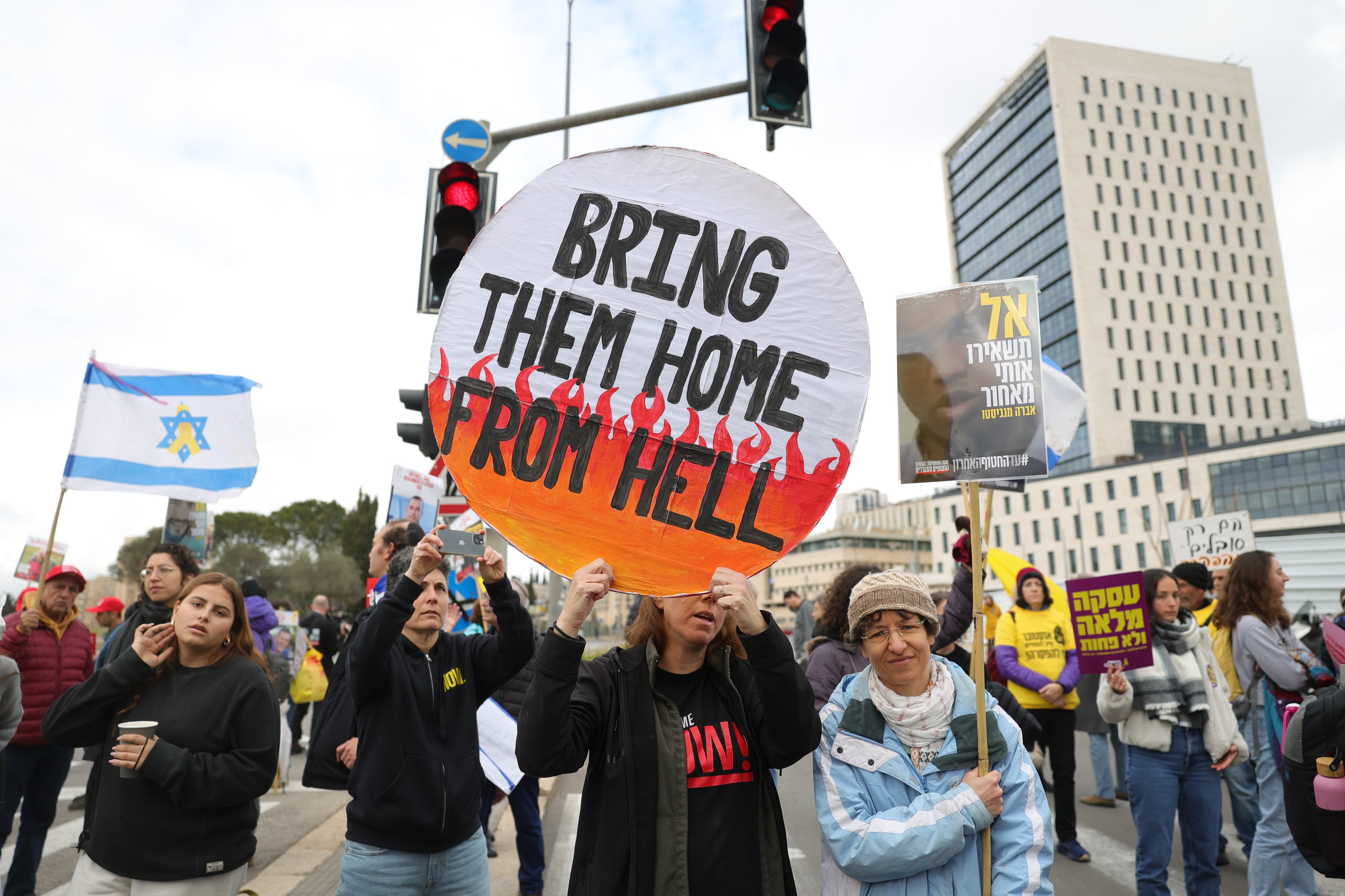 Jerusalén (-), 11/02/2025.- Familiares de rehenes israelíes retenidos por Hamás en Gaza y sus partidarios portan pancartas durante una protesta frente a la oficina del primer ministro Benjamín Netanyahu.