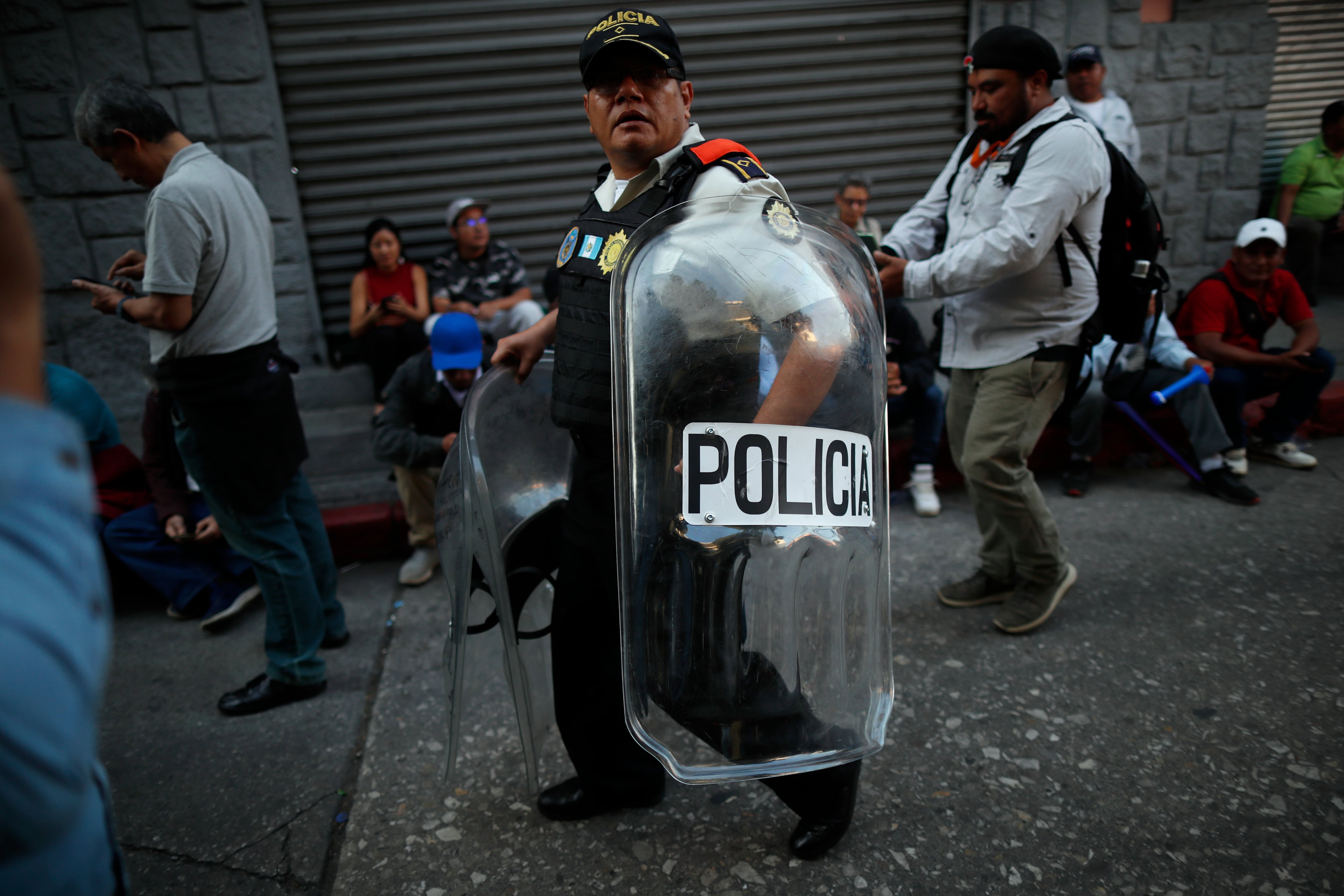 AME9579. CIUDAD DE GUATEMALA (GUATEMALA), 14/01/2024.- Un policía se retira con varios escudos después de choques entre policías y manifestantes en las afueras del Congreso hoy, en Ciudad de Guatemala (Guatemala). Decenas de manifestantes protagonizan choques con agentes antidisturbios en las afueras del Congreso de Guatemala, donde está sesionando la comisión que debe llevar a cabo la juramentación de los 160 diputados de la legislatura 2024-2028, requisito obligatorio para que se pueda concretar la investidura hoy de Bernardo Arévalo de León como presidente del país, en reemplazo de Alejandro Giammattei. EFE/ Bienvenido Velasco