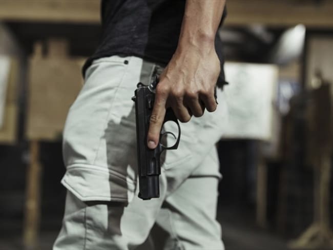 Imagen de referencia de una persona armada con pistola. Foto: Getty Images / Westend61