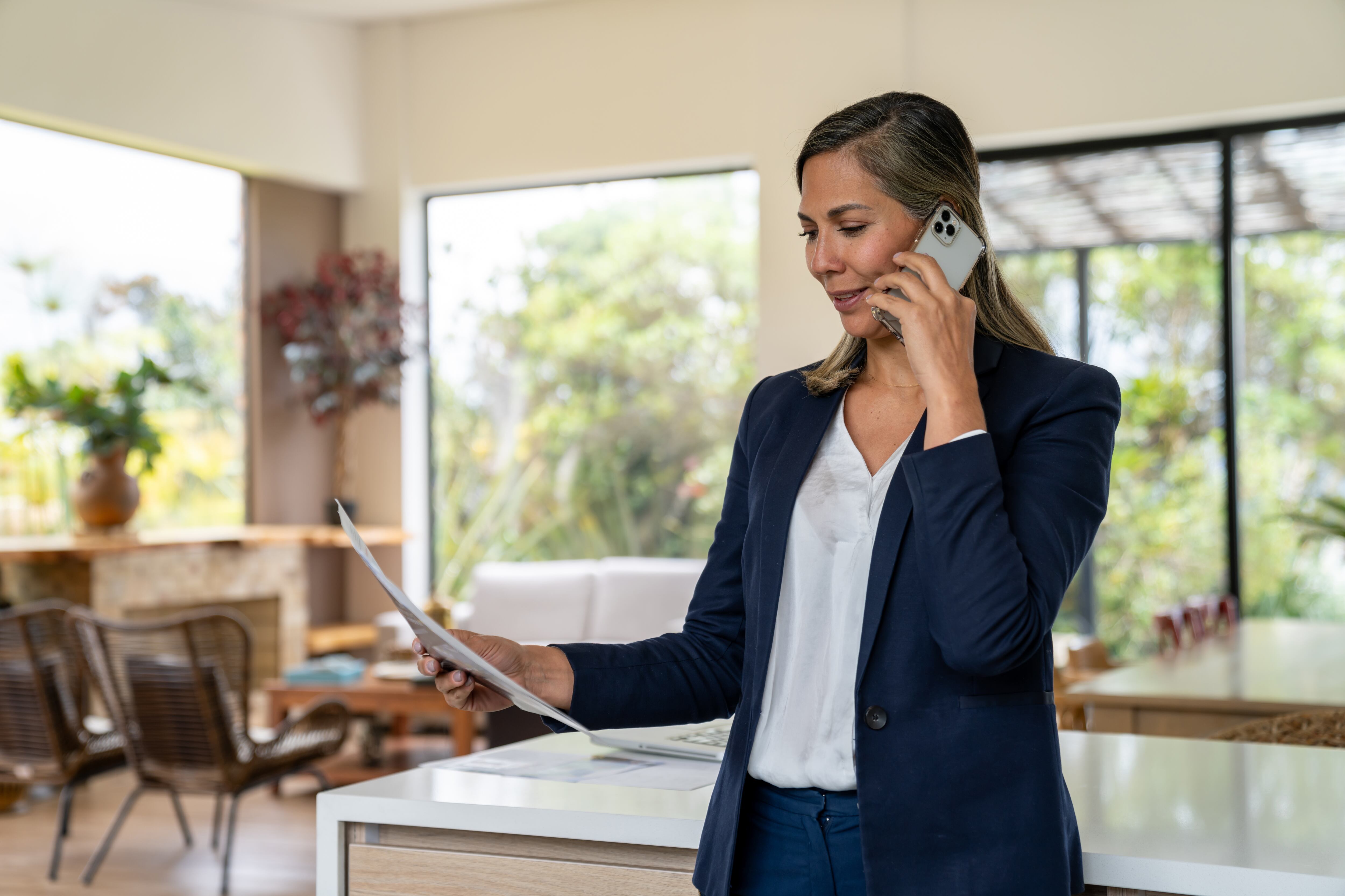 Agente inmobiliario hablando por teléfono mientras tiene un contrato - Fotografía de stock