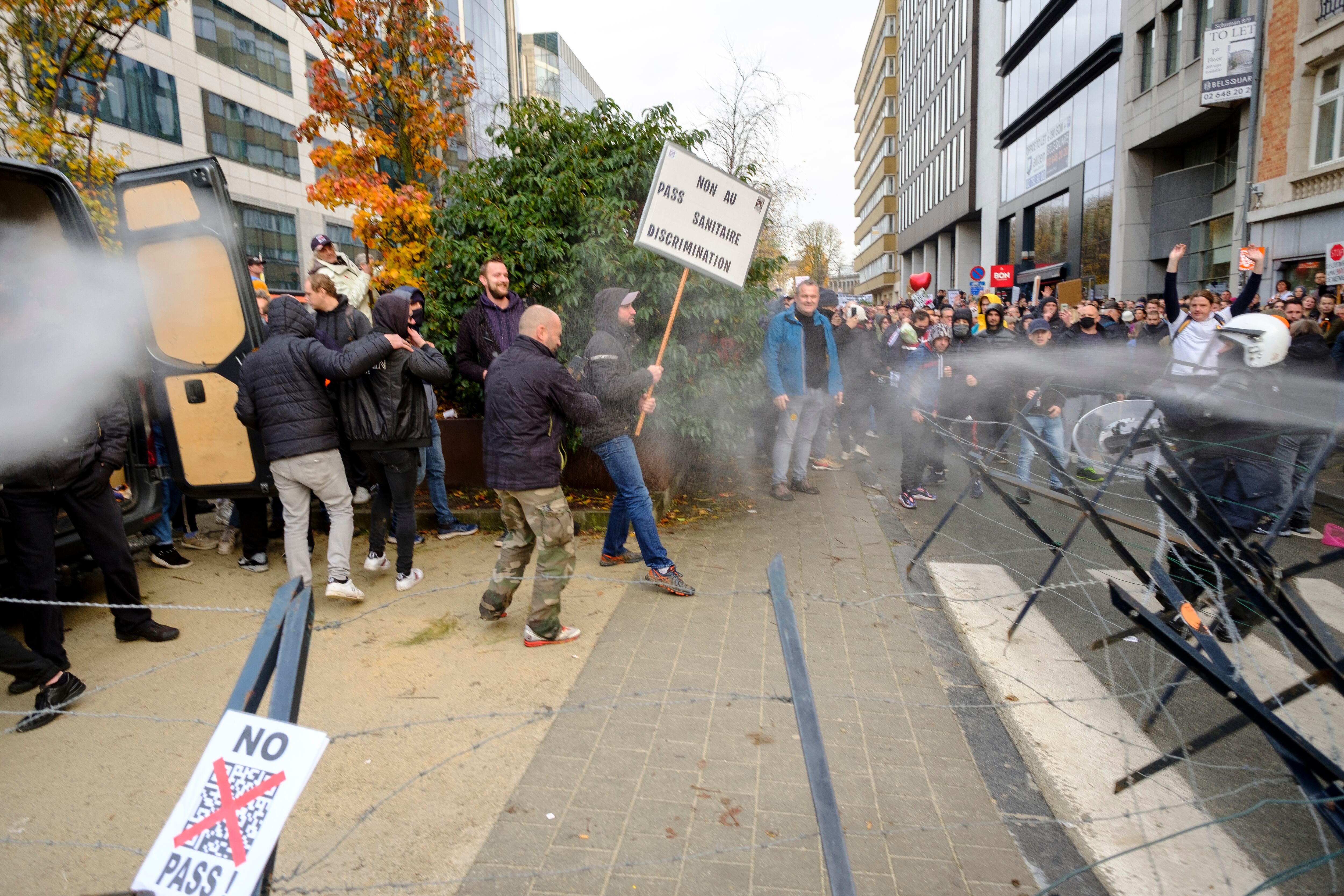 BRUSSELS, BELGIUM - NOVEMBER 21: Police spray protesters with gas as they gather in front of the Gare du Nord for the demonstration entitled "Together for freedom" on November 21, 2021 in Brussels, Belgium. Police estimate 35,000 people gathered at 1 pm in front of the Gare du to protest against the Covid pass, which they consider to be a factor of division in the society. (Photo by Thierry Monasse/Getty Images)