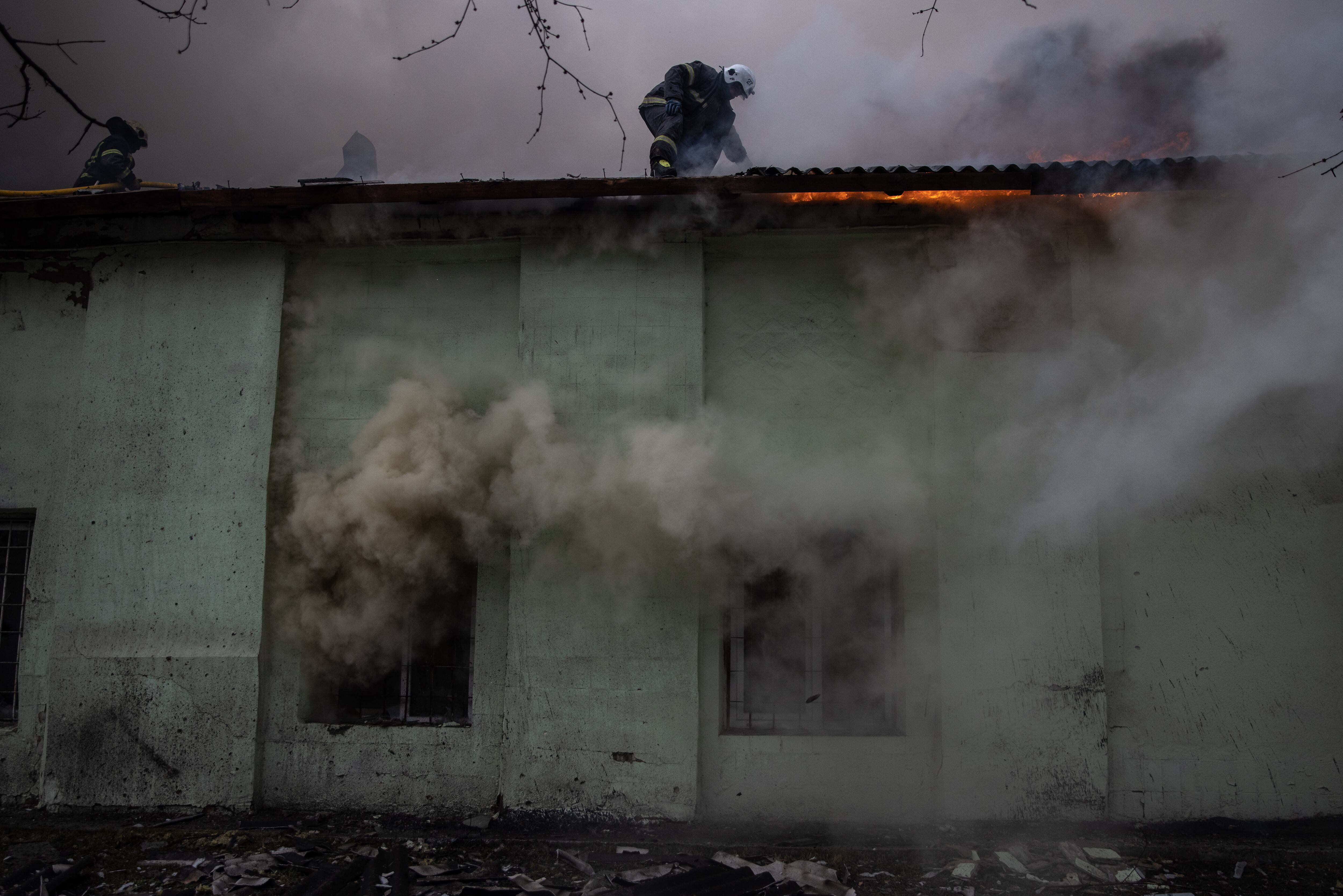 KHARKIV, UKRAINE - MARCH 28: Firefighters work to extinguish a fire at a warehouse after it was hit by Russian shelling on March 28, 2022 in Kharkiv, Ukraine. More than half Kharkiv's 1.4 million people have fled the city since Russia's invasion on Feb. 24, which was followed by weeks of intense bombardment. Russian forces remain to the city's north and east, but have met heavy resistance from Ukrainian troops here. (Photo by Chris McGrath/Getty Images)